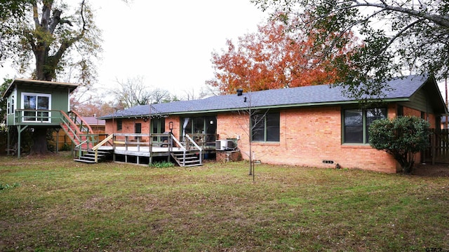 rear view of property with a yard, a deck, and central AC unit