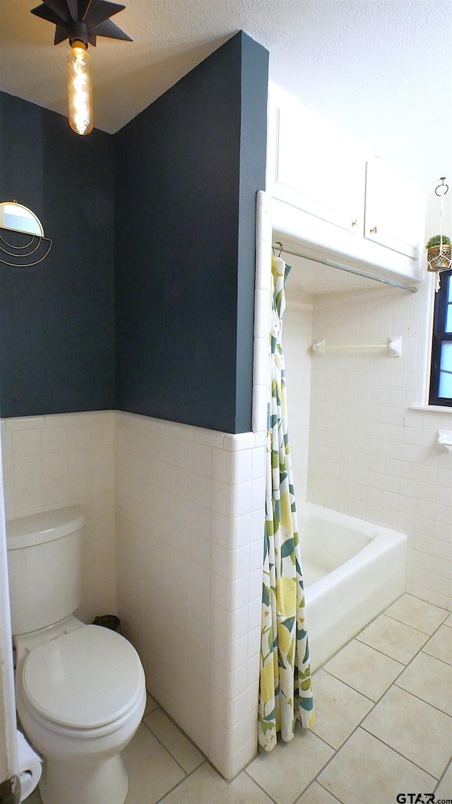 bathroom featuring tile patterned floors, tile walls, and toilet