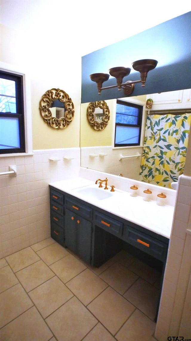 bathroom with a wealth of natural light, vanity, tile patterned floors, and tile walls