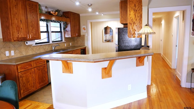 kitchen featuring a kitchen breakfast bar, refrigerator, sink, and backsplash