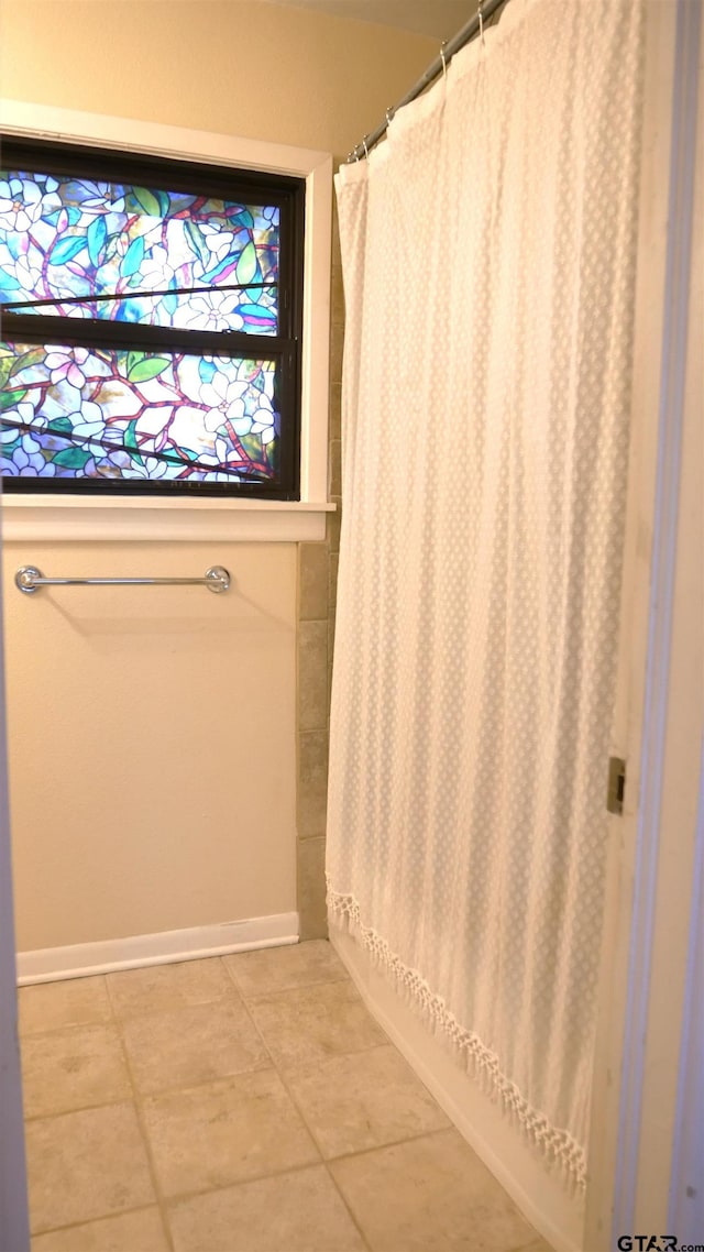 bathroom with tile patterned flooring and shower / bath combo with shower curtain