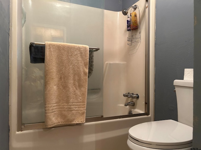 bathroom with toilet and combined bath / shower with glass door