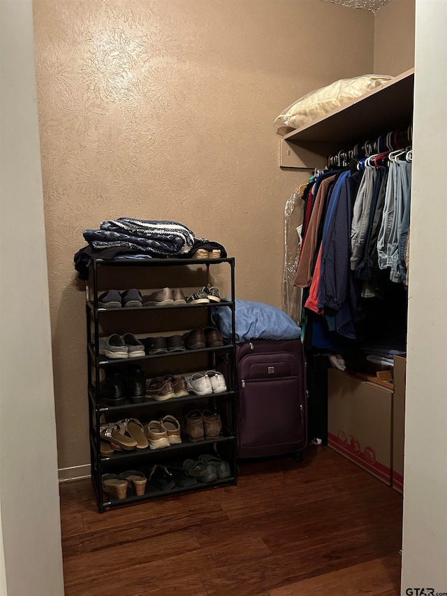 walk in closet with dark hardwood / wood-style floors