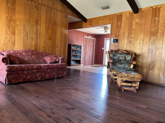 interior space with wood walls, dark hardwood / wood-style floors, and beam ceiling