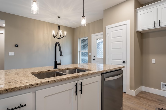 kitchen featuring sink, stainless steel dishwasher, white cabinets, and light stone counters