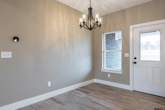 foyer entrance with a chandelier and light wood-type flooring