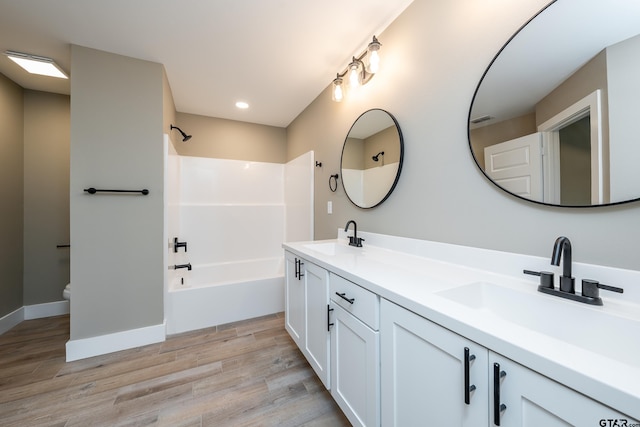 full bathroom featuring hardwood / wood-style flooring, vanity, shower / bathing tub combination, and toilet