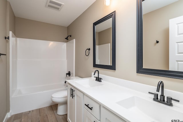 full bathroom with vanity, wood-type flooring, bathing tub / shower combination, and toilet