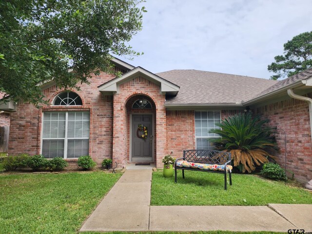 670 Frederick Cir, Flint, TX 75762 - view of front of home with brick siding, a shingled roof, and a front lawn