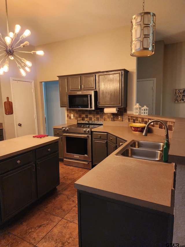 670 Frederick Cir, Flint, TX 75762 - kitchen featuring stainless steel appliances, a chandelier, tasteful backsplash, a peninsula, and dark tile patterned floors
