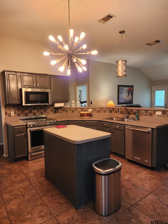 670 Frederick Cir, Flint, TX 75762 - kitchen with stainless steel appliances, decorative backsplash, a kitchen island, light countertops, and pendant lighting