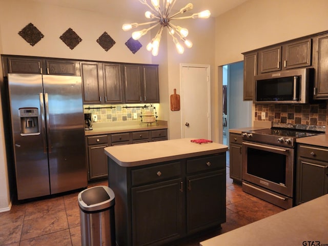 670 Frederick Cir, Flint, TX 75762 - kitchen featuring appliances with stainless steel finishes, a chandelier, tasteful backsplash, light countertops, and a center island