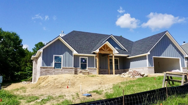 24062 Sun Ridge Rd, Lindale, TX 75771 - view of front facade with brick siding, board and batten siding, an attached garage, and roof with shingles