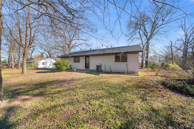 rear view of property featuring a lawn