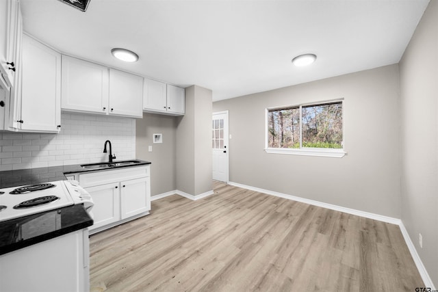 kitchen with sink, light hardwood / wood-style floors, tasteful backsplash, and white cabinetry