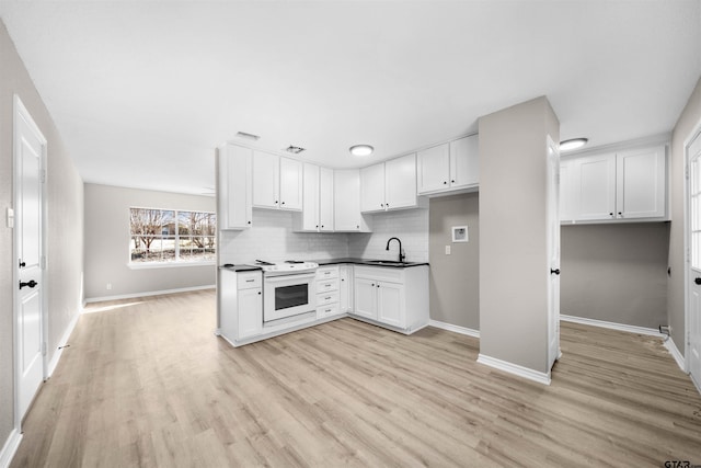 kitchen with sink, white electric range oven, white cabinets, and tasteful backsplash