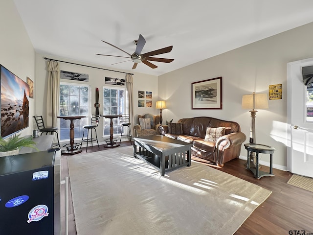 living area featuring ceiling fan, wood finished floors, and baseboards