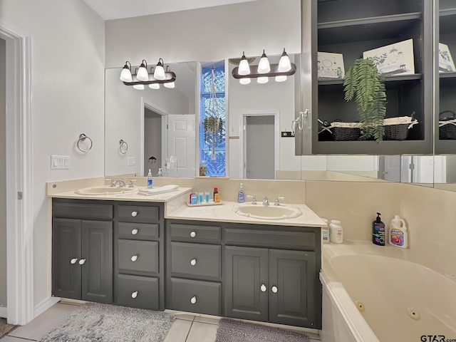 bathroom with double vanity, tile patterned flooring, a tub with jets, and a sink