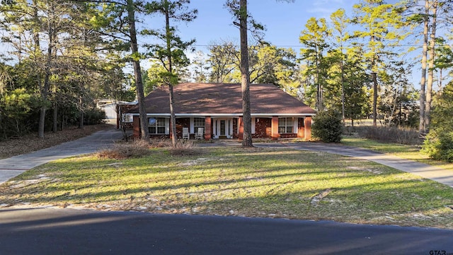 view of front of house with a front yard, covered porch, and driveway