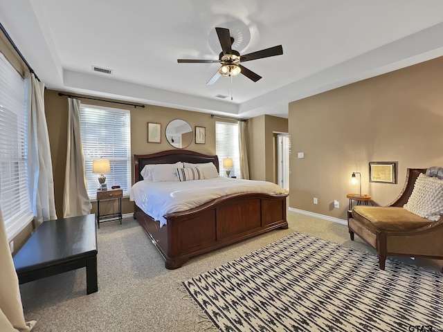 bedroom with a ceiling fan, light colored carpet, visible vents, and baseboards