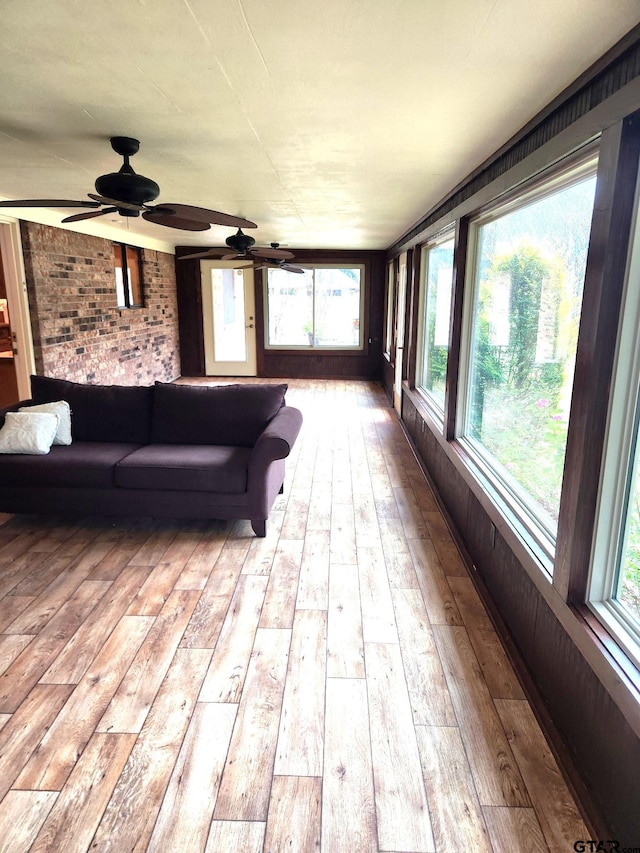 unfurnished sunroom featuring ceiling fan and a healthy amount of sunlight