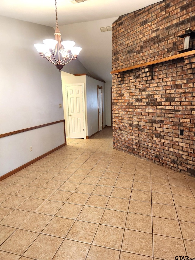 unfurnished room with a chandelier, light tile patterned floors, vaulted ceiling, and brick wall