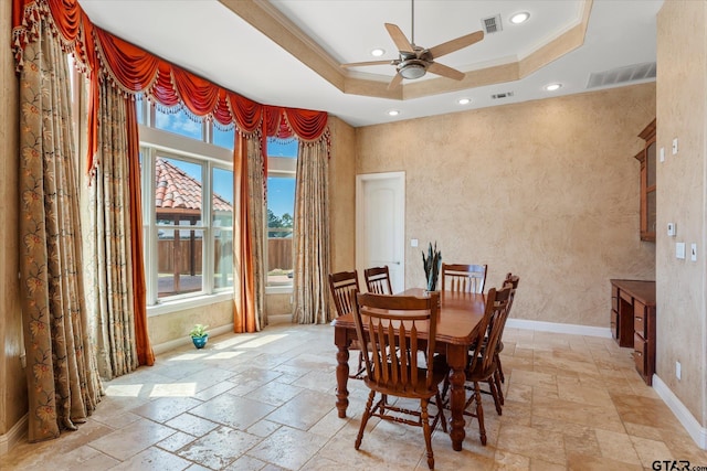 dining area featuring a wealth of natural light, ceiling fan, crown molding, and a tray ceiling