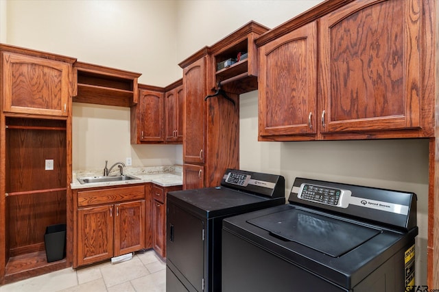 clothes washing area featuring cabinets, washing machine and dryer, and sink