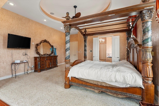 bedroom featuring beamed ceiling, carpet flooring, and decorative columns