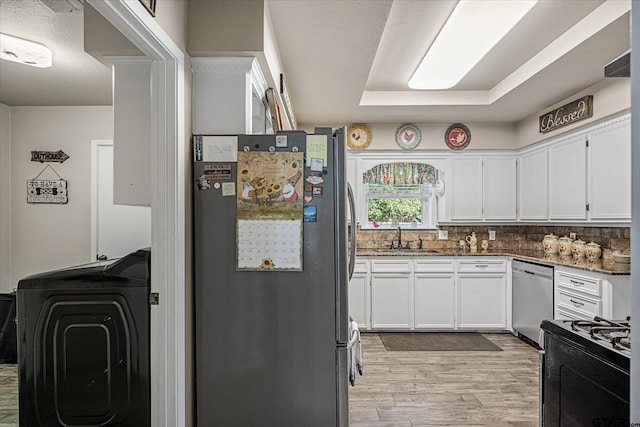 113 Granada Sq, Canton, TX 75103 - kitchen with stainless steel appliances, light wood-style flooring, a sink, washer / dryer, and white cabinets
