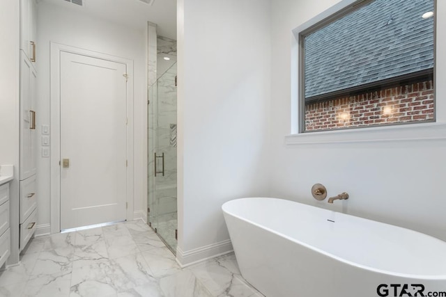 full bathroom with vanity, baseboards, a marble finish shower, a freestanding tub, and marble finish floor