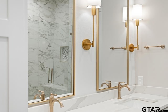 bathroom with a marble finish shower and vanity