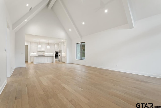 unfurnished living room featuring baseboards, beamed ceiling, recessed lighting, light wood-style flooring, and high vaulted ceiling