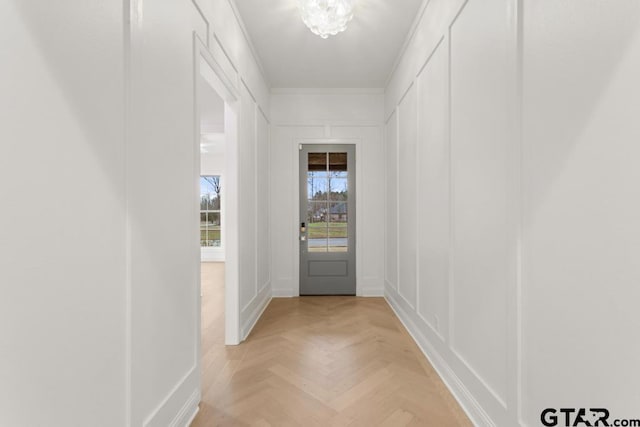 entryway with crown molding and a decorative wall