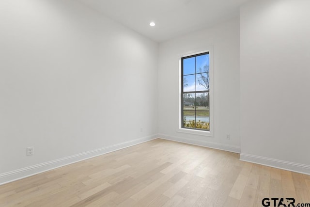 spare room with recessed lighting, light wood-style floors, and baseboards