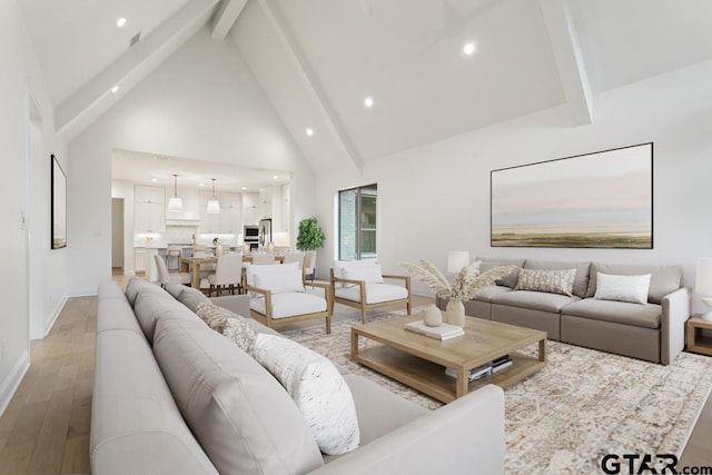 living room with beam ceiling, high vaulted ceiling, recessed lighting, light wood finished floors, and baseboards