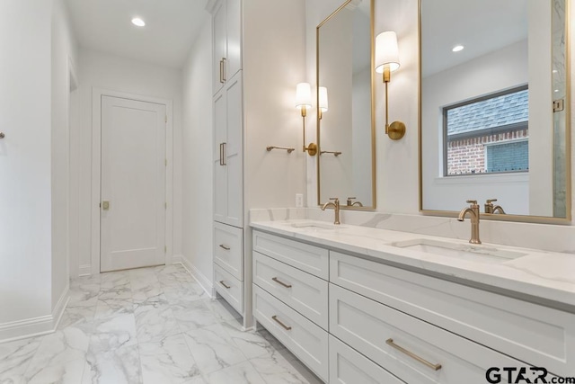 bathroom with a sink, marble finish floor, recessed lighting, and double vanity