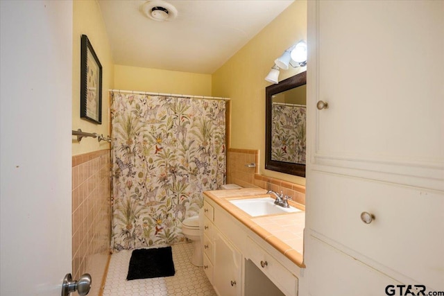 315 Ridgecrest Dr, Tyler, TX 75701 - full bathroom featuring tile walls, tile patterned floors, vanity, a wainscoted wall, and curtained shower