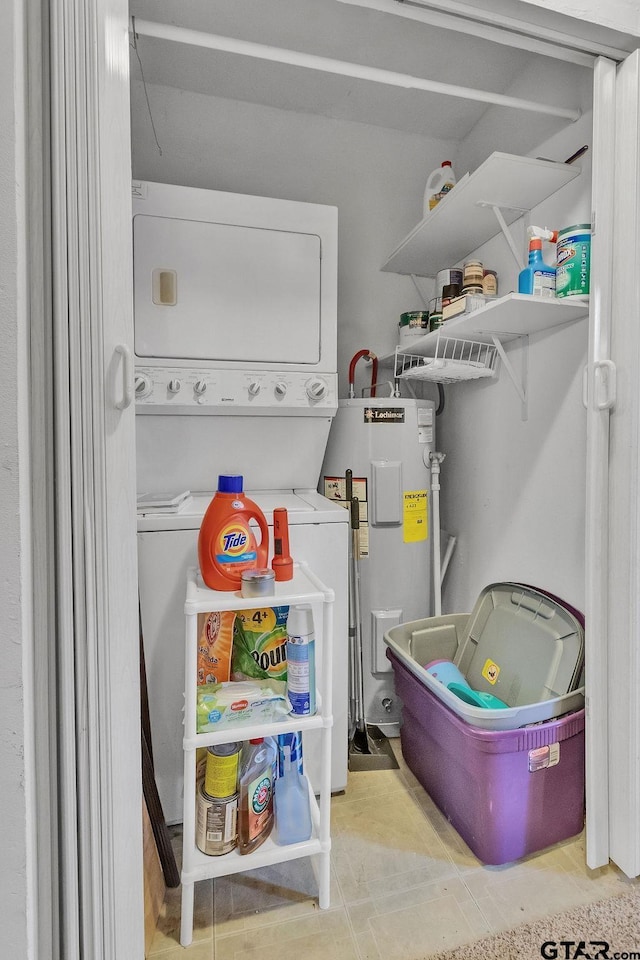 clothes washing area with electric water heater and stacked washer and clothes dryer