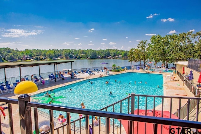 view of swimming pool featuring a patio and a water view