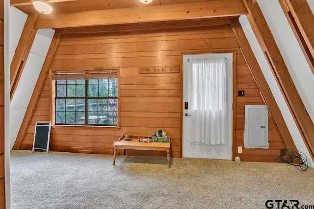 interior space with wooden walls, electric panel, carpet, and vaulted ceiling with beams