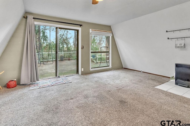 unfurnished living room featuring ceiling fan, light colored carpet, and vaulted ceiling