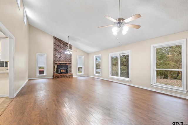 unfurnished living room with ceiling fan, wood-type flooring, a fireplace, and high vaulted ceiling