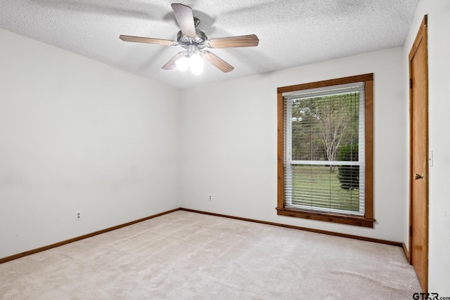 carpeted empty room with a textured ceiling and ceiling fan