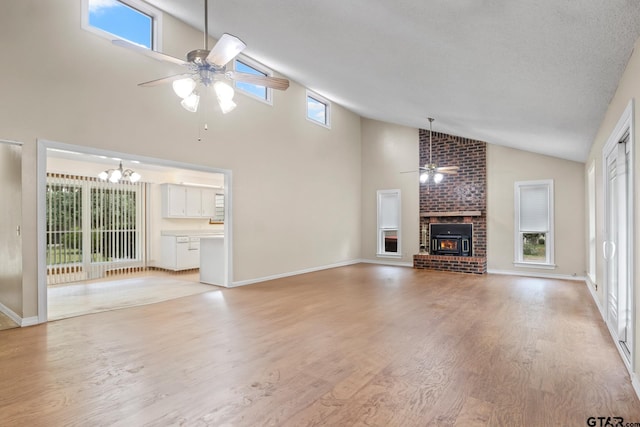 unfurnished living room with a wealth of natural light, high vaulted ceiling, and light hardwood / wood-style floors