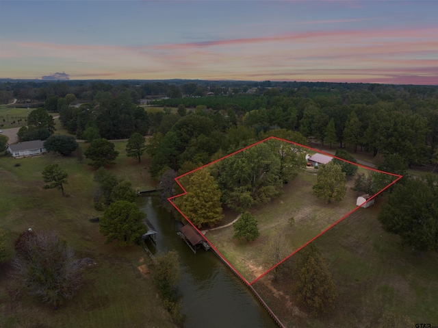 aerial view at dusk featuring a water view