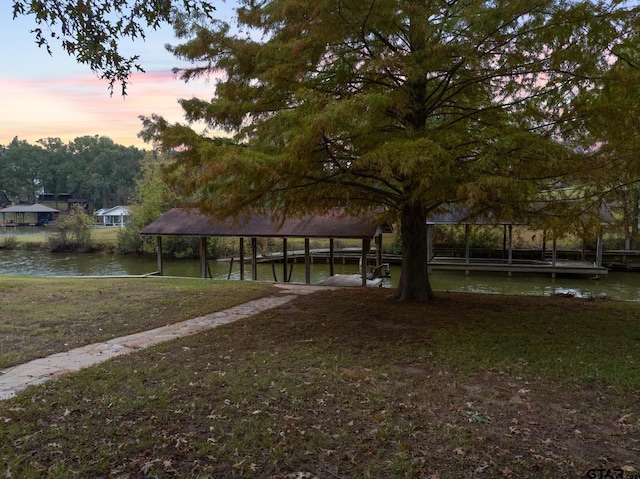 view of property's community with a lawn and a water view