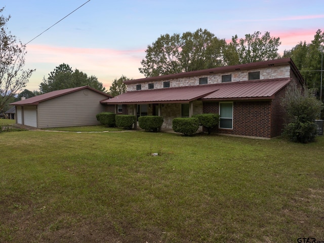 view of front of house featuring a yard, a garage, and an outdoor structure