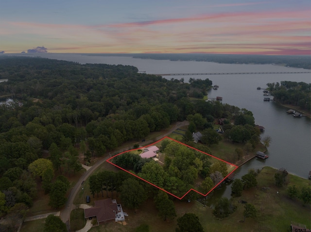 aerial view at dusk featuring a water view