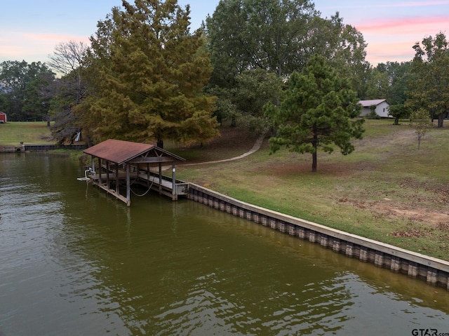 view of dock with a water view and a lawn